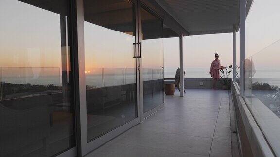 穿着衣服的女人走在豪华阳台上日落海景