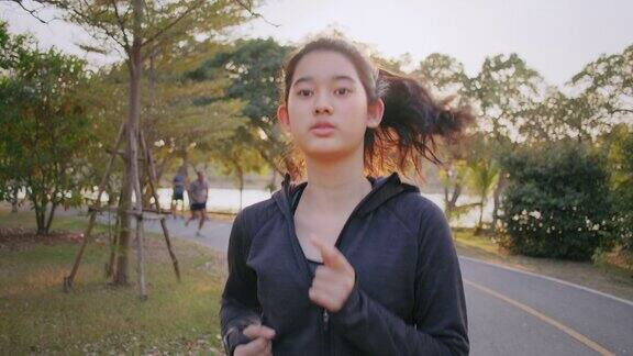 迷人的亚洲少女在公园里跑步年轻女子晨跑锻炼