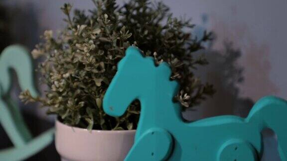 微型木制摇摆马玩具和一个花盆在木架子上