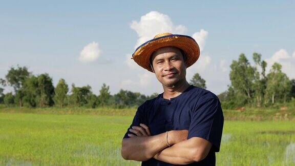 年轻的农民站在稻田里双臂交叉