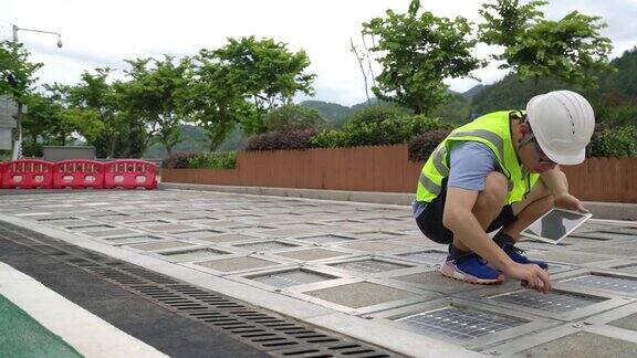 年轻的技术人员检查安装在道路上的太阳能电池板