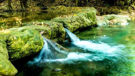 流动的水和波浪瀑布在美丽的绿色自然时间流逝