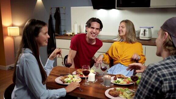 四对快乐的朋友两对夫妇在家庭厨房用餐年轻人在宴会上有说有笑
