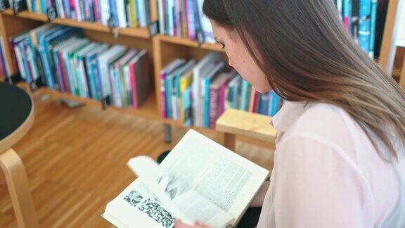 一个女人坐在图书馆里看书