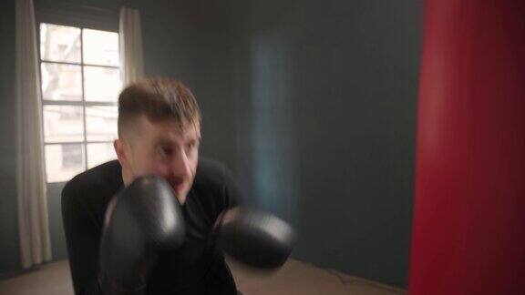 拳击运动员拳击手训练他的出拳打沙袋训练日在拳击馆里用他的脚打击背部照明