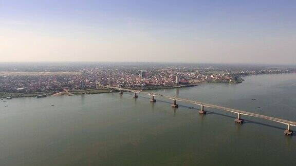 无人机飞向横跨湄公河的一座大桥背景是一座亚洲小镇