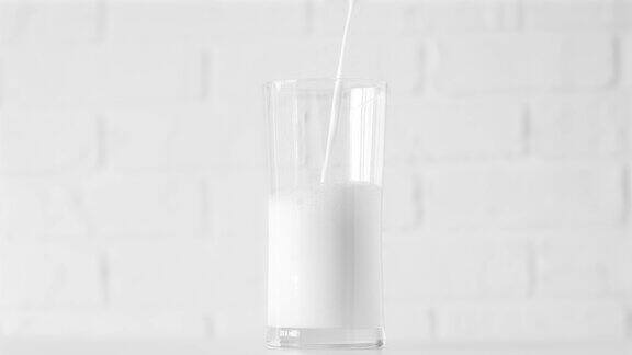 牛奶倒入玻璃上的白色背景特写