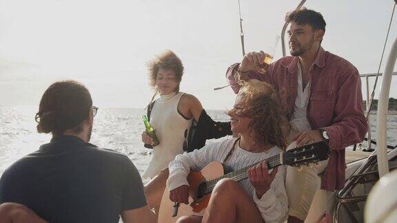 一名女子在帆船甲板上对着一群朋友弹着吉他