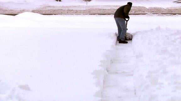 从人行道上铲雪的男人