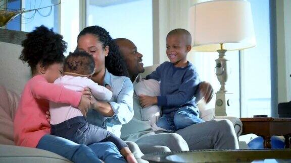 一个非裔美国家庭三个孩子聚在沙发上