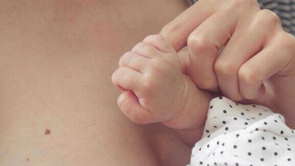 一个新生儿握着妈妈的手指的特写镜头