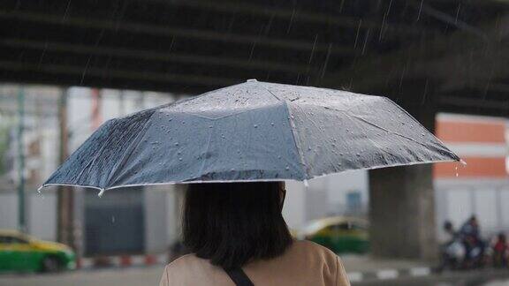 一个亚洲女人在雨中等出租车