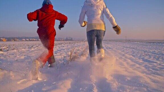 妈妈和女儿在雪中奔跑