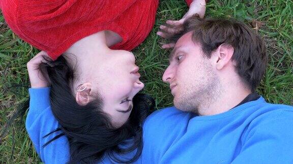 躺在草地上相爱的情侣互相凝视着对方的眼睛