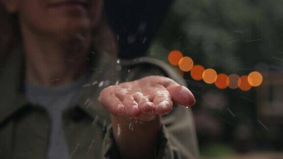 雨水落在一个打着伞的女人的手掌上