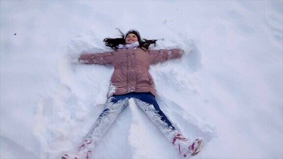 十几岁的女孩躺在雪地上做雪天使