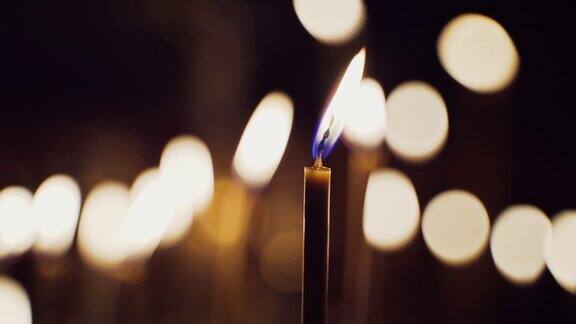 一支蜡烛在模糊的灯光下明亮地燃烧着