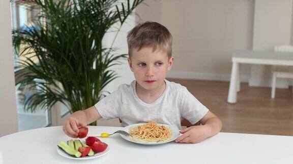 一个小男孩在厨房里微笑着在家吃意大利面好孩子食欲概念