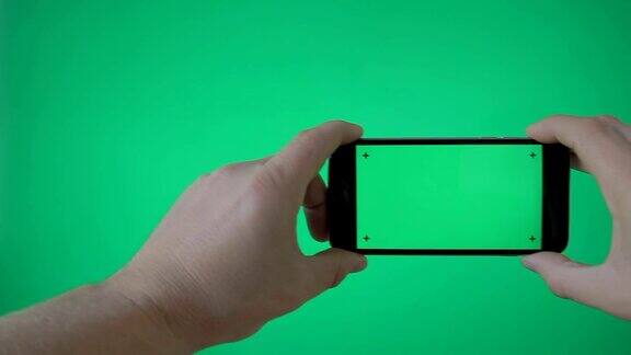 手持智能手机(风景)在绿色屏幕BG