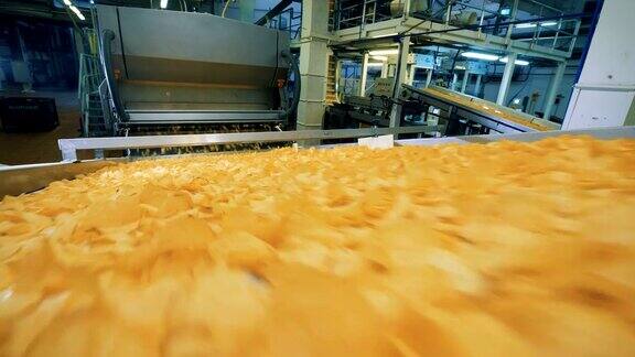 黄色的薯片在食品工厂的传送带上运输
