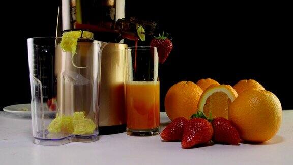 用咀嚼榨汁机榨取新鲜的草莓和橙汁