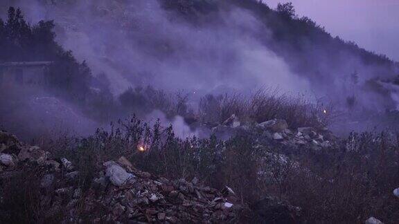 在山区森林大火中燃烧的草和瓦砾堆产生的烟雾