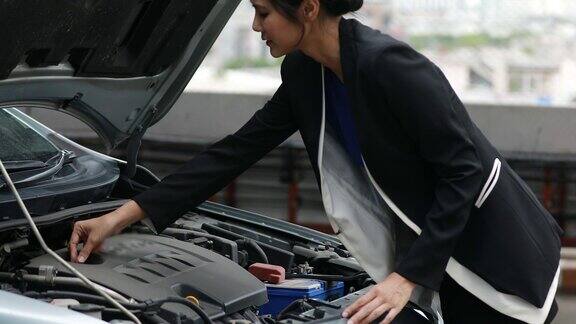 男商人帮助女商人检查和修理坏了的汽车