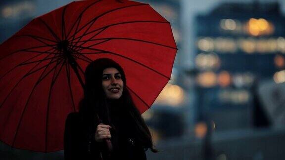 红伞下的快乐女人在市中心散步