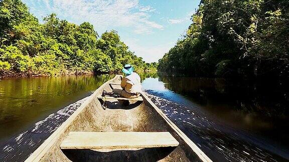 男性探险家在亚马逊河上乘坐土著独木舟航行