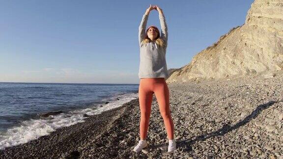 运动女性在寒冷季节做健身有氧运动在海滩上锻炼训练和健康