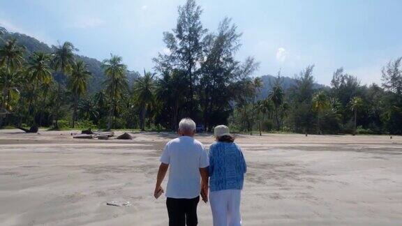 亚洲老年夫妇一起散步在海边的背景周末假期老年人快乐生活