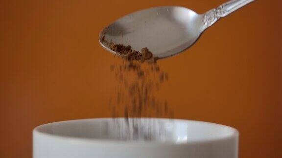 速溶咖啡碎片从勺子在杯子中的慢动作新鲜早晨热巧克力近缓慢的运动咖啡粉从勺子上掉下来可可早上特写镜头