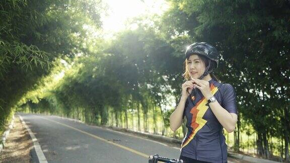 橙色的女自行车手戴着防护头盔锻炼训练骑自行车在公园
