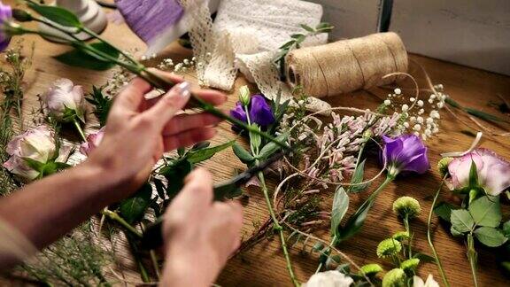 年轻女性金发花商准备花束花店老板的手在她的花店制作花束花店在花店剪花茎Slowmotion拍摄