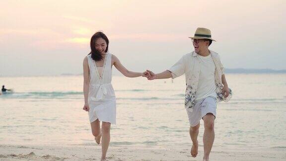 4K快乐的亚洲情侣在夏日夕阳下一起在沙滩上玩耍