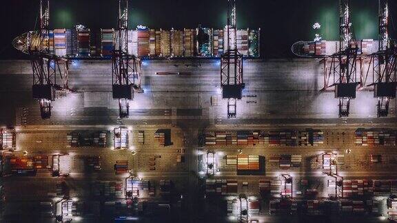 繁忙的工业港口集装箱船在夜间鸟瞰图