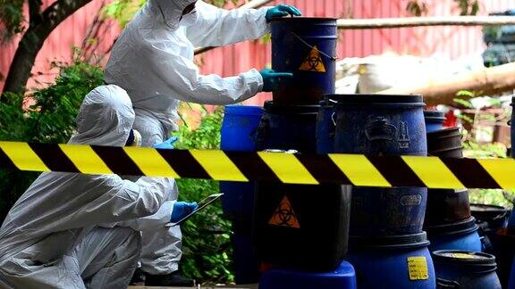 两位亚洲科学家通过鉴定危险的化学物质而穿上防护服