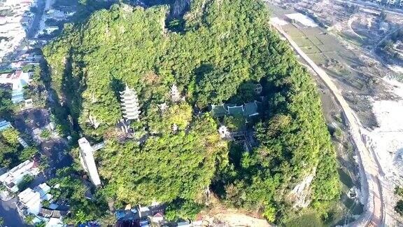 Flycam升起在被城市包围的绿色山丘上的寺庙