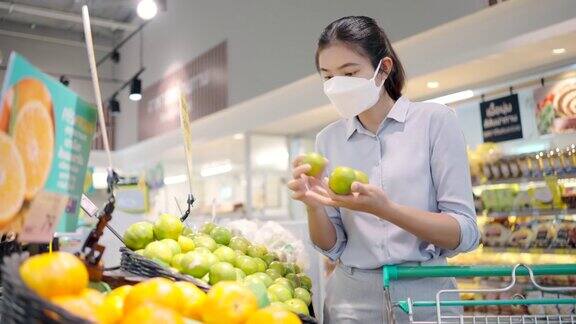 亚洲女孩戴着口罩保护她的脸在超市购物