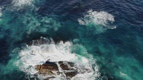 鸟瞰俯视图4k视频由无人机海浪打破海滩和岩石美丽的海景