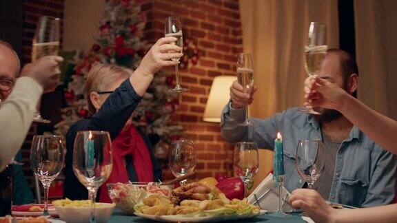 幸福的一家人在圣诞餐桌上举杯共饮起泡酒