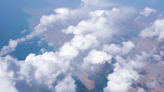 旅行时从窗口飞机上俯瞰棕色的山脉和云朵降落