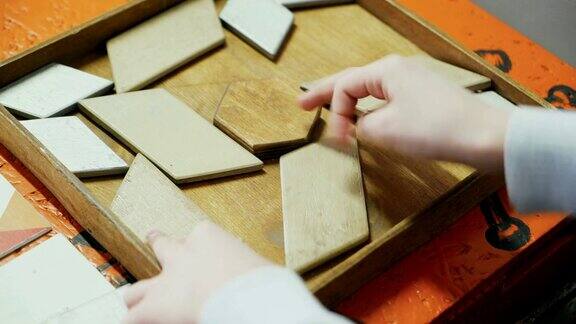 特写一个孩子的手在玩一个木制的拼图