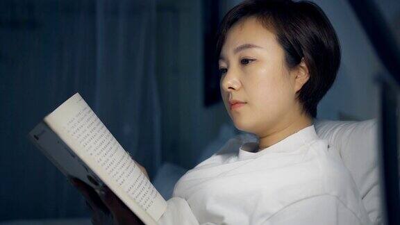 晚上躺在床上看书的亚洲女人