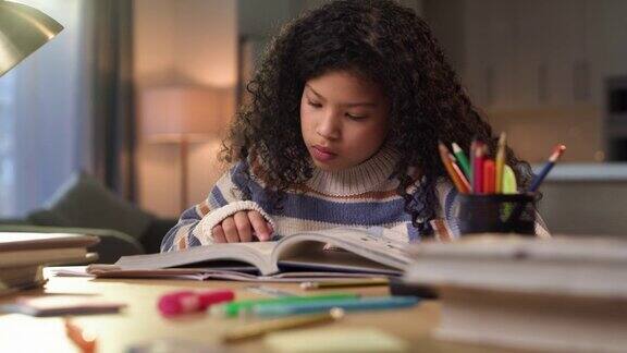 一个小女孩独自坐在家里读课本的4k视频片段