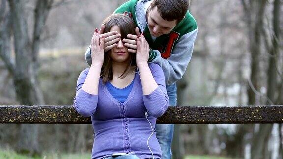 年轻男子遮住了一个惊喜的女朋友的眼睛