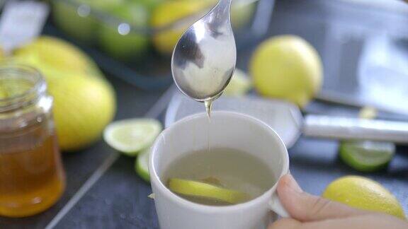 女性用手平静地将蜂蜜倒入一杯柠檬茶中