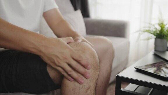 亚洲男人按摩他的膝盖疼痛和感觉不好触发点医疗保健概念