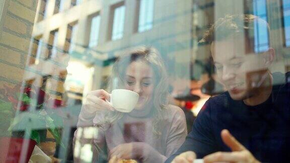 年轻美丽的男女在一个舒适的咖啡馆约会聊天喝咖啡和一起玩