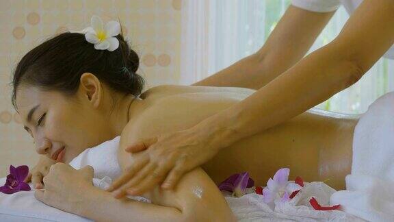 美丽的亚洲女人享受精油按摩疗法
